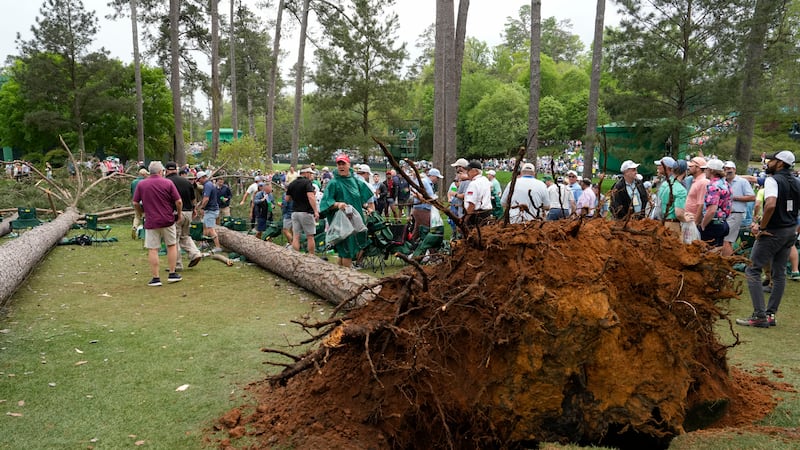 Patrons depart the course after trees blew over on the 17th hole during the second round of...