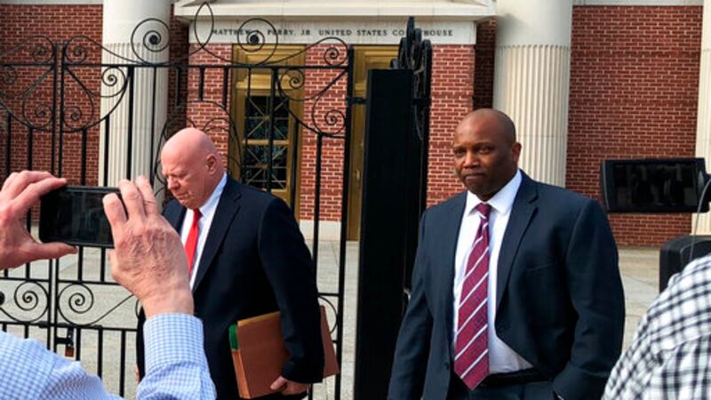 Former prosecutor Dan Johnson, right, walks out of the federal courthouse in Columbia, S.C.,...