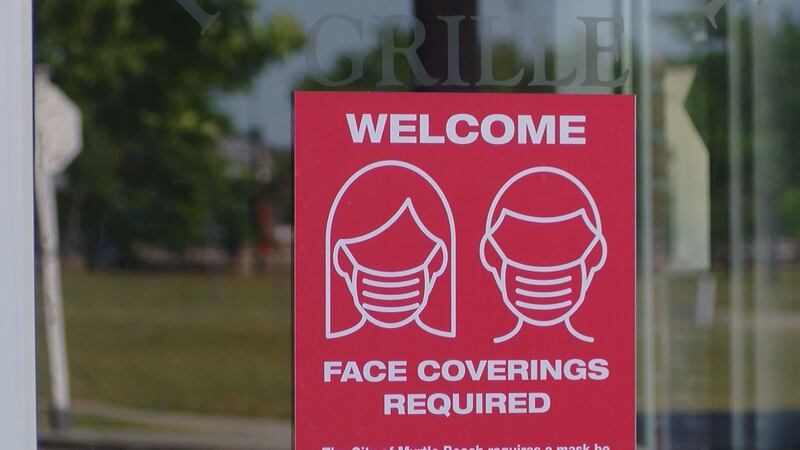 A mask required sign still hangs outside a restaurant in Myrtle Beach.